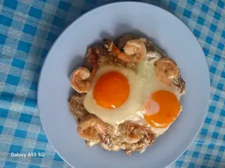 Rice with garlic shrimp and a cracked egg.