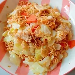 Stir-fried instant noodles with egg and chicken pieces.