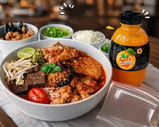 Two sets of Khanom Jeen Nam Ngiao (Thai rice noodles with spicy pork broth) plus one bottle of orange juice.