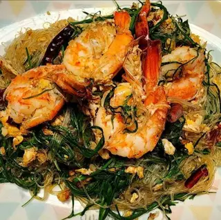 Stir-fried glass noodles with dried chilies, egg, and cha-om leaves.